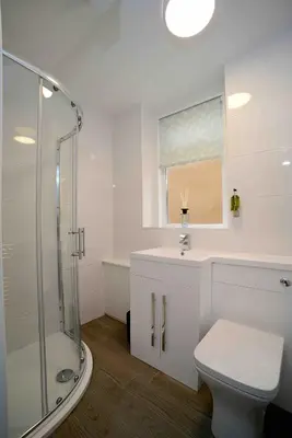a bathroom with a shower and a toilet and a sink at Twelve Apartments in Blackpool
