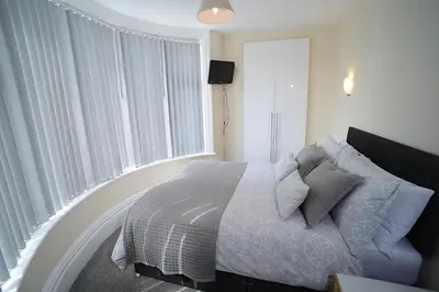 a bedroom with a bed and a large window at Twelve Apartments in Blackpool