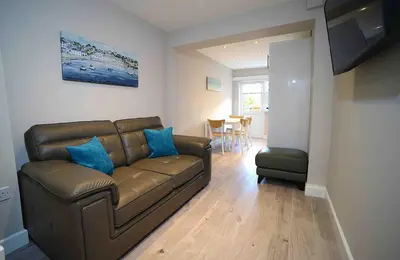 a living room with a brown couch and a table at Twelve Apartments in Blackpool