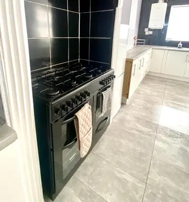 a black stove in a kitchen with a tile floor at No. 206 - Spacious 5 Bed in Liverpool
