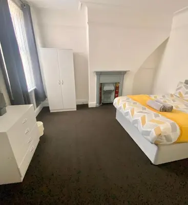 a white bedroom with a bed and white cabinets at No. 206 - Spacious 5 Bed in Liverpool