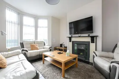 a living room with couches and a fireplace at 5 bedroom house, free parking, near football, sleeps 8 in Liverpool