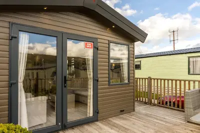 a storage shed with sliding doors on a deck at Wiswell View Lodge: Pendle View Holiday Park in Clitheroe