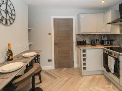 a kitchen with a counter and a table with chairs at 12 Merefell Road in Carnforth