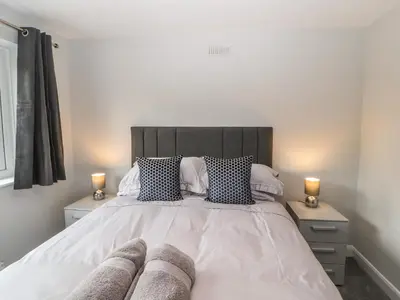 a bedroom with a large bed with two night stands at 12 Merefell Road in Carnforth