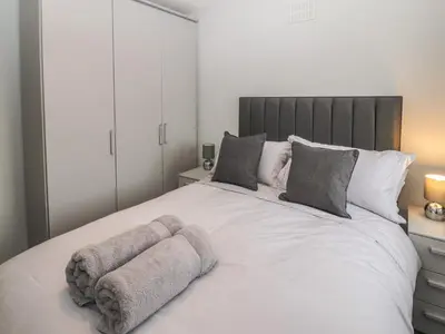a bedroom with a large white bed with two pillows at 12 Merefell Road in Carnforth