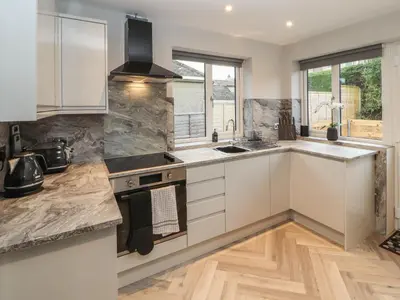 a kitchen with white cabinets and a sink at 12 Merefell Road in Carnforth