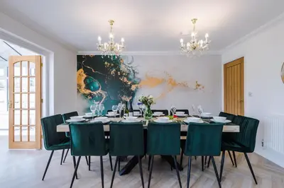 a dining room with a table and green chairs at Damson House- Spacious, Modern 6 bedroom Executive House - Ideal for Work Teams or Multi-Generational Families in Great Mitton