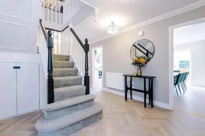 a staircase in a home with a vase of flowers on a table at Damson House- Spacious, Modern 6 bedroom Executive House - Ideal for Work Teams or Multi-Generational Families in Great Mitton