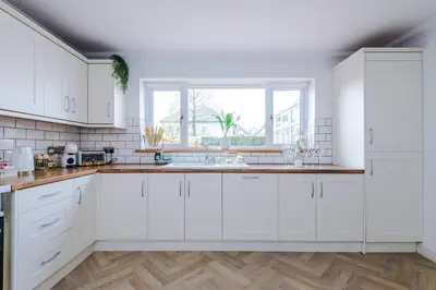 a white kitchen with white cabinets and a window at Damson House- Spacious, Modern 6 bedroom Executive House - Ideal for Work Teams or Multi-Generational Families in Great Mitton