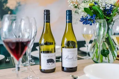 two bottles of wine sitting on a table with wine glasses at Damson House- Spacious, Modern 6 bedroom Executive House - Ideal for Work Teams or Multi-Generational Families in Great Mitton