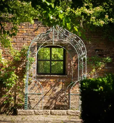 a metal archway with a window in a brick wall at Victorian Copper Cottage in Lancaster