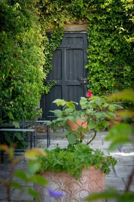 a black door with a pink rose in front of it at Victorian Copper Cottage in Lancaster