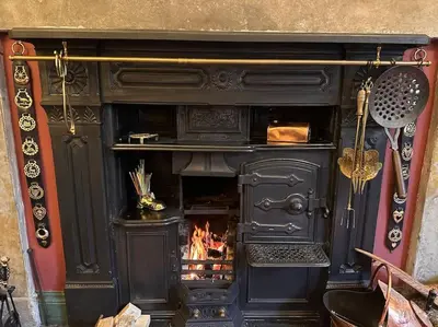 a black fireplace with a fire in it at Victorian Copper Cottage in Lancaster