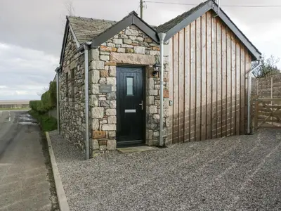 a small building with a door on the side of a road at Driftwood Studio in Ulverston