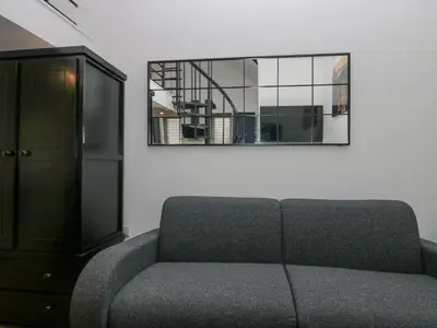 a living room with a couch and a mirror at Driftwood Studio in Ulverston