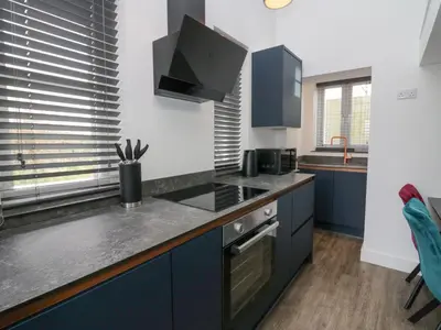 a kitchen with blue cabinets and a counter top at Driftwood Studio in Ulverston