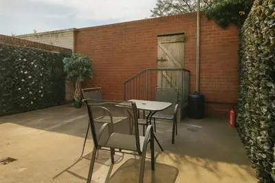 a table and chairs in front of a brick building at Sidemersey Livings - Botanic Residence in Liverpool