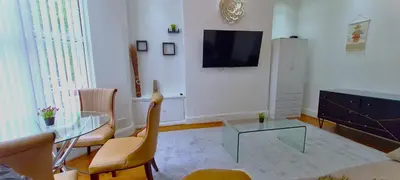 a living room with a glass table and a television at Sidemersey Livings - Botanic Residence in Liverpool