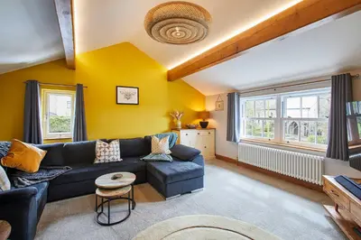 a living room with a blue couch and yellow walls at Host & Stay - Lime Tree House in Holme