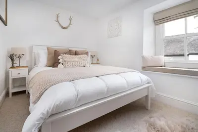 a white bedroom with a bed and a window at Wharton Cottage, Cartmel, Lake District Retreat - Ridgestone in Cartmel