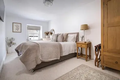 a bedroom with a bed and a table with a lamp at Wharton Cottage, Cartmel, Lake District Retreat - Ridgestone in Cartmel