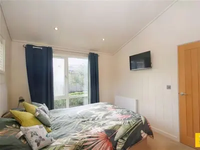 a bedroom with a bed and a window at Tarka Halt 1 - Haven Lakeland Leisure in Flookburgh