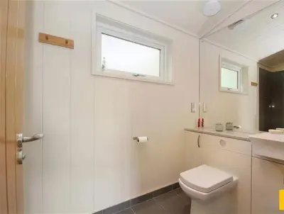 a bathroom with a toilet and a sink and a window at Tarka Halt 1 - Haven Lakeland Leisure in Flookburgh