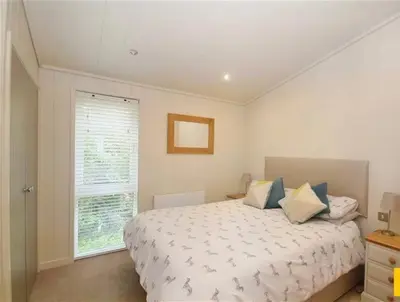 a bedroom with a large bed and a window at Tarka Halt 1 - Haven Lakeland Leisure in Flookburgh