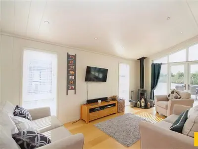 a living room with two couches and a flat screen tv at Tarka Halt 1 - Haven Lakeland Leisure in Flookburgh