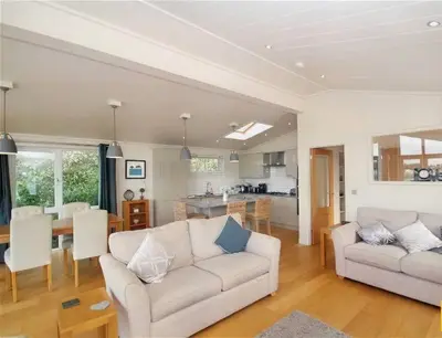 a living room with a couch and a table and a kitchen at Tarka Halt 1 - Haven Lakeland Leisure in Flookburgh
