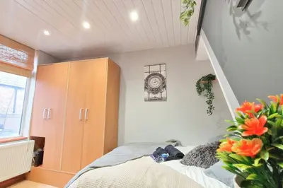 a bedroom with a bed and a cabinet and flowers at Great Liverpool Location! in Liverpool