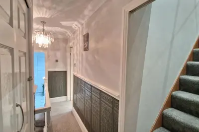 a hallway with stairs and a chandelier at Great Liverpool Location! in Liverpool