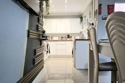 a kitchen with white cabinets and a white refrigerator at Great Liverpool Location! in Liverpool