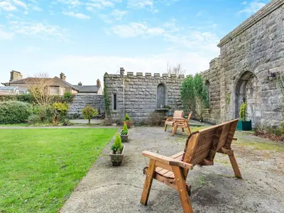 a garden with two benches and a stone building at Uk46865 - Helvellyn in Ulverston
