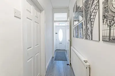 a hallway with a white door and paintings on the walls at Scott House - Air Host & Stay - Parking - Contractor friendly in Liverpool