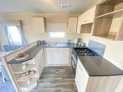 a small kitchen with a sink and a stove at Angella's Caravan - Morecambe in Morecambe