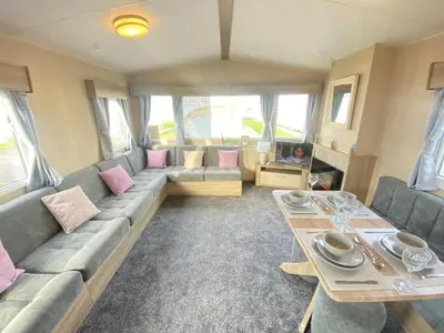 a living room with a couch and a table at Angella's Caravan - Morecambe in Morecambe