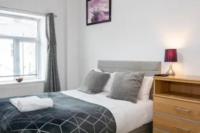 a bedroom with a bed with a window and a dresser at James Street Terrace Great Harwood in Great Harwood