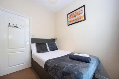 a small bedroom with a bed and a white door at James Street Terrace Great Harwood in Great Harwood