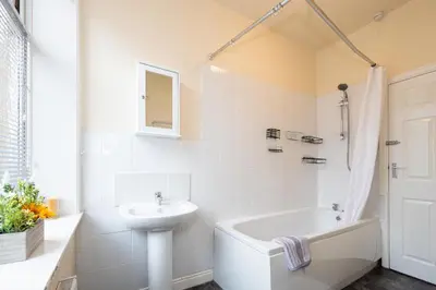 a white bathroom with a sink and a bath tub at James Street Terrace Great Harwood in Great Harwood