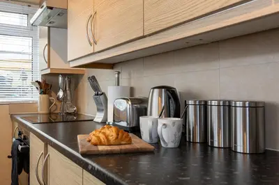 a kitchen counter with a loaf of bread on a cutting board at James Street Terrace Great Harwood in Great Harwood