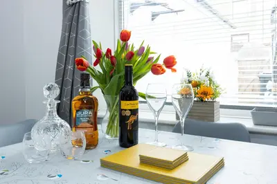 a table with wine bottles and glasses and flowers at James Street Terrace Great Harwood in Great Harwood