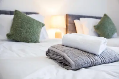 a pile of towels sitting on top of a bed at Liverpool 6 beds, Up to 22 percent- Contractors Dream in Liverpool
