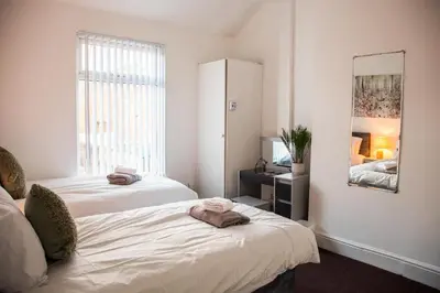 a bedroom with two beds and a mirror at Liverpool 6 beds, Up to 22 percent- Contractors Dream in Liverpool