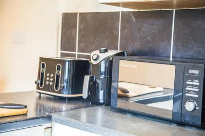 a kitchen counter with a toaster and a microwave at Liverpool 6 beds, Up to 22 percent- Contractors Dream in Liverpool