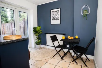 a dining room with a table and a fireplace at Haydock Cozy 2-Bedroom Home with Free Parking in Haydock