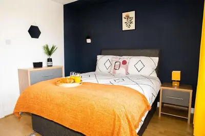 a bedroom with a bed with a bowl of fruit on it at Haydock Cozy 2-Bedroom Home with Free Parking in Haydock