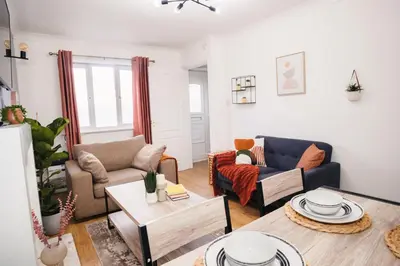 a living room with two couches and a table at Haydock Cozy 2-Bedroom Home with Free Parking in Haydock