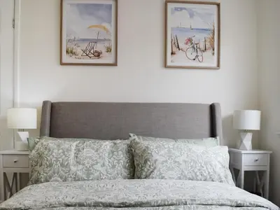 a bedroom with two framed pictures above a bed at Commonside Cottage in Lytham St Annes